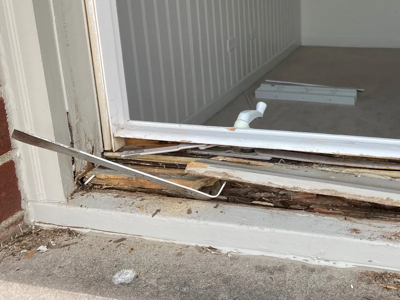 Rotted wood exposed along the bottom of a casement window frame