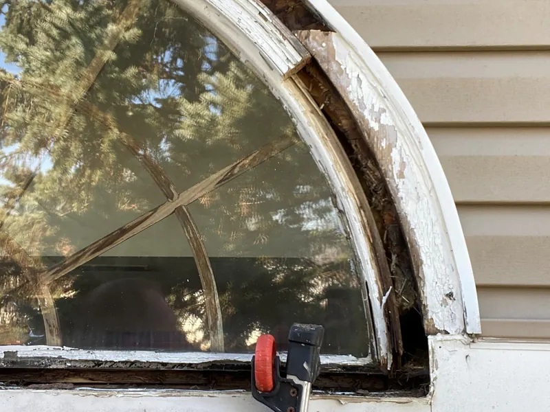 Rotted arched window frame and trim before repair