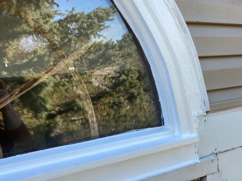 Arched window frame rebuilt and painted after repair