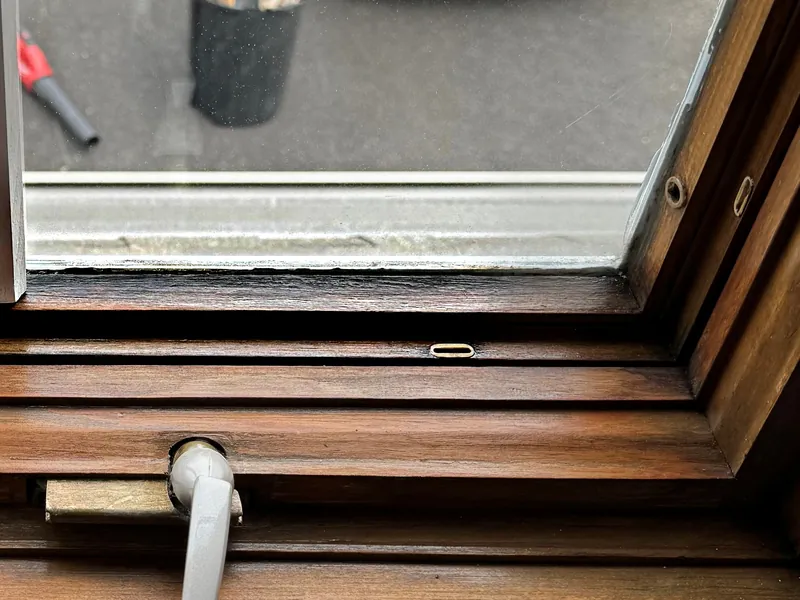 Moisture residue along the bottom of the glass on a wood casement window